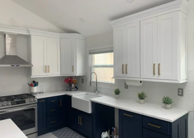 A stylish kitchen showcasing a monochrome color palette with black cabinets and white countertops.