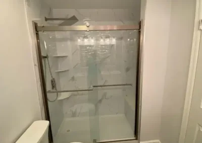 A modern bathroom featuring a frameless glass shower and minimalistic fixtures.