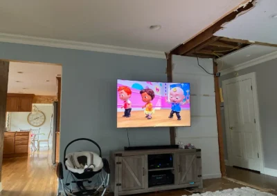 A spacious TV lounge featuring open shelving, a cozy rug, and a stylish entertainment unit.