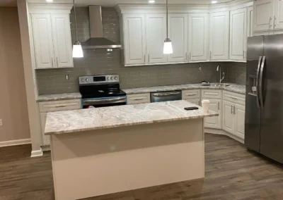 A spacious kitchen featuring double ovens, a prep island, and custom lighting.