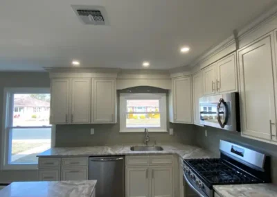 A small kitchen with a built-in pantry, modern cabinets, and a pull-out spice rack.