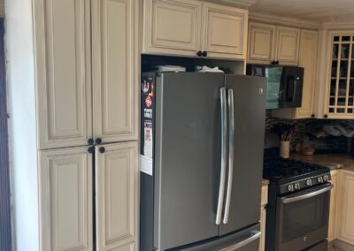 A luxury kitchen featuring gold hardware on navy blue cabinets and a quartz countertop.