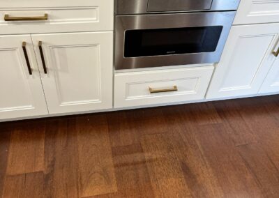 A monochromatic black kitchen with glossy cabinets and a sleek minimalist design.