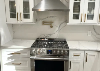 A stylish high-contrast kitchen featuring black cabinets and a white quartz countertop.
