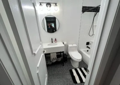 A nature-inspired bathroom with potted plants and large windows for natural light.