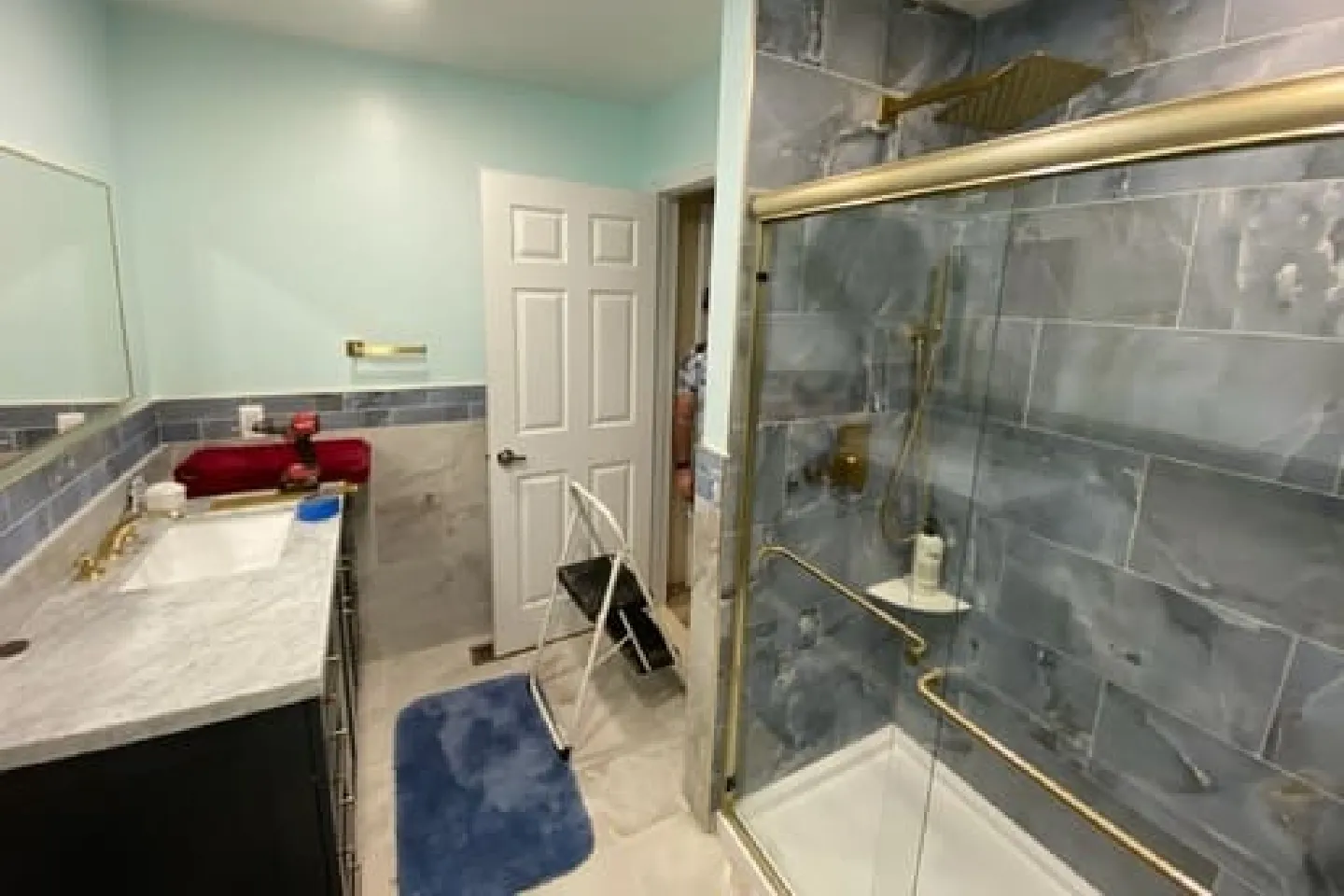 Bathroom with Gold Fixtures A fashionable bathroom with floral wallpaper and gold accent fixtures.